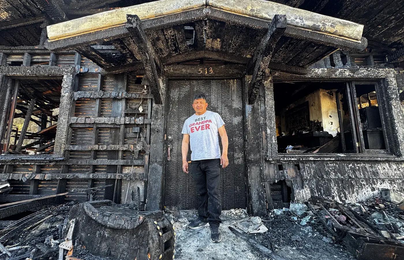 Juan Galicia stands in front of his burnt out home